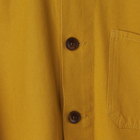 Close up of the buttons on the yellow buttoned overshirt.