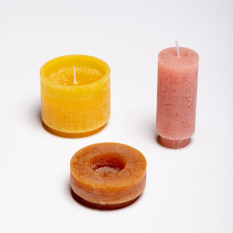 Three stackable candles, unstacked, in the colours red, orange and yellow.