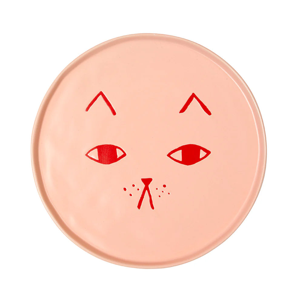 Round pink ceramic late with red cat face design on a white background