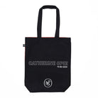 Reverse of tote bag with 'Catherine Opie To Be Seen' text against black on a white background