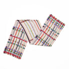 A multicoloured scarf with a geometric pattern of stripes and squares folded in a zig zag shape.