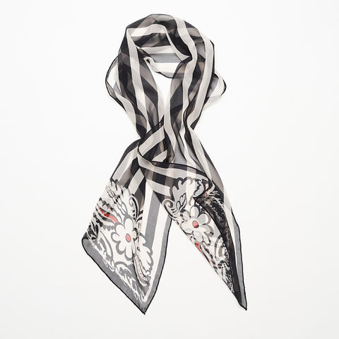 Styled long black and white striped silk scarf with floral motif.