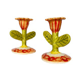 A pair of hand-painted flower candlestick holders, on an angle. 