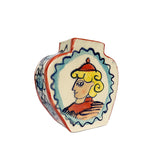 Hand-painted vase with a head in profile with blonde hair and a red hat, side view.