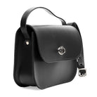 Black leather handbag with a strap and silver clasp on a white background