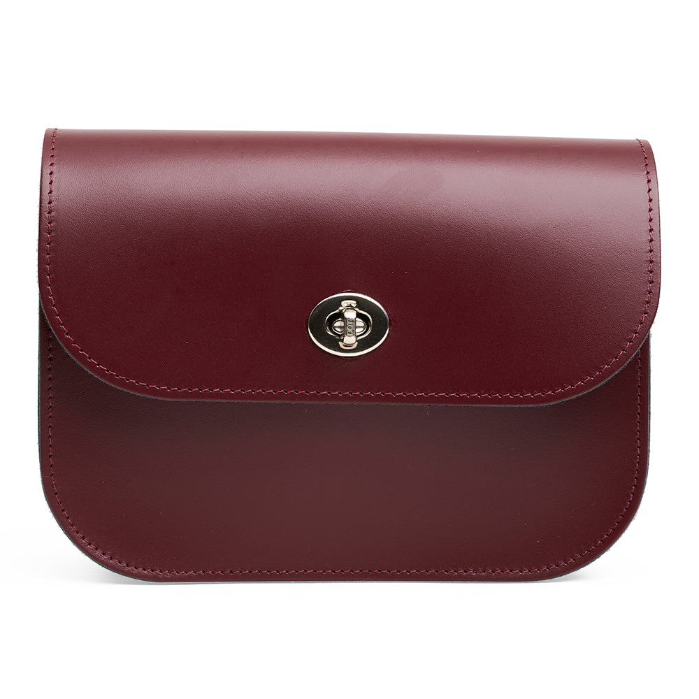 Maroon leather handbag with a metal clasp on a white background