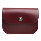 Maroon leather handbag with a metal clasp on a white background