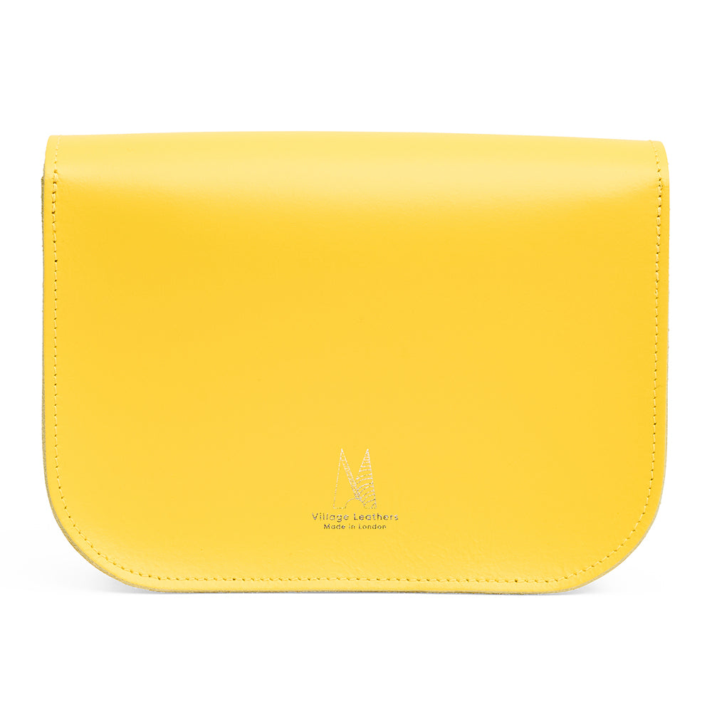 Reverse of yellow leather handbag with village leathers logo on a white background