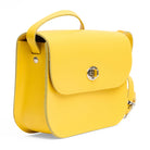 Side view of yellow leather shoulder bag with a strap and gold clasp on a white background