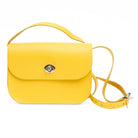 Yellow leather handbag with a strap on a white background