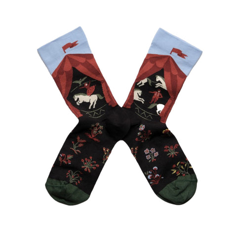 A pair of socks featuring a red circus tent design with horses inside.