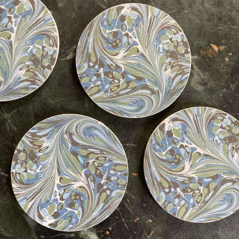 A group of four marbled green and blue coasters.