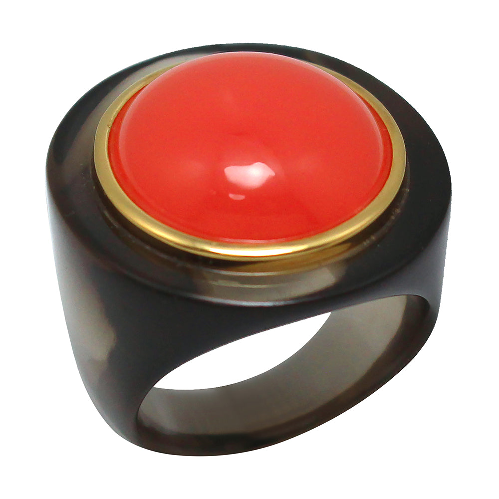 A chunky round resin ring with a cloudy dark base and a bright red central charm surrounded by a circle of gold.