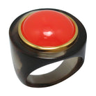 A chunky round resin ring with a cloudy dark base and a bright red central charm surrounded by a circle of gold.