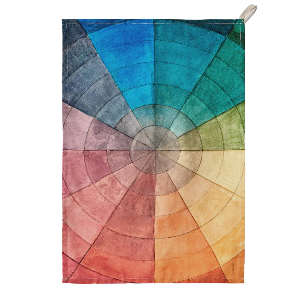 Colour wheel design with gradient colours on a tea towel against a white background