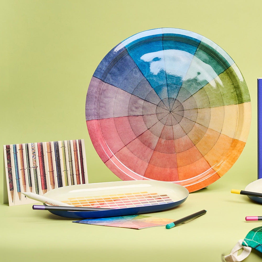 Colour wheel design tray with illustrated paint swatch tray and pencil design card on a green background