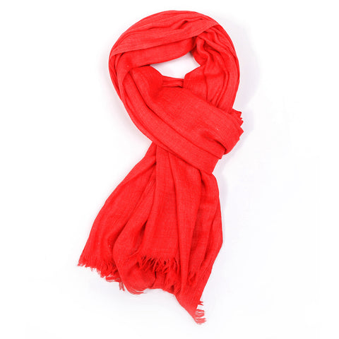 A plain coral red scarf tied in a styled knot.