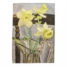 Decorative tea towel with yellow flowers and a glass pitcher on a white background