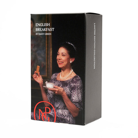 A box of tea featuring a photographic portrait of Dame Margot Fonteyn in a dress with a pearl necklace and holding a cup of tea and a biscuit.