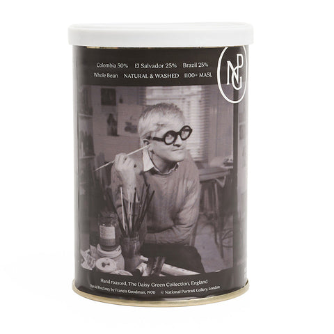 Reverse of metal coffee tin featuring a black and white photo of David Hockney holding a paintbrush to his ear. 