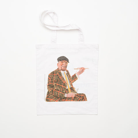 White tote bag with David Hockney's "Self-Portrait, 2022" on the front. 
