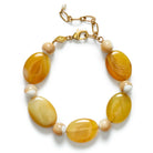 Bracelet with yellow and beige beads on a white background