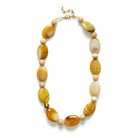 Chunky beaded necklace in butterscotch brown on a gold chain against a white background