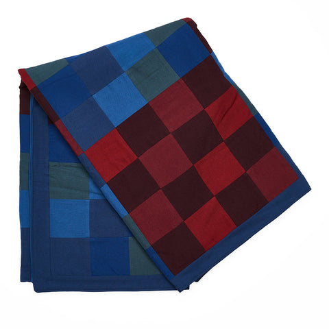 Chequered multicoloured blue, red and green quilted throw.