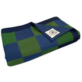 Neatly folded chequered throw blanket in blue and green with the top layer folded down, exposing the NPG logo.
