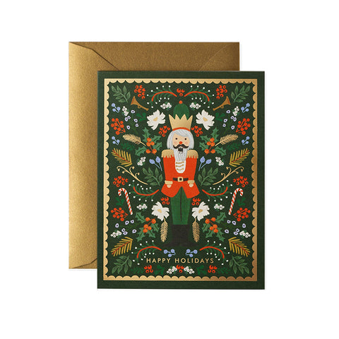 A green card with a Nutcracker on the front of it with gold borders and a gold envelope. 