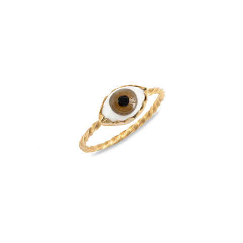 A textured gold band ring with a white and brown eyeball charm in the centre.