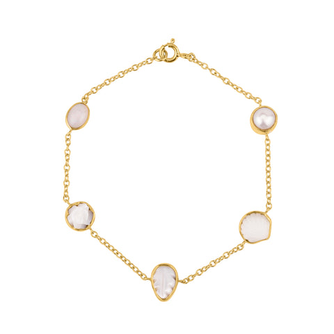 Five white opal and pearl charms on a gold chain bracelet.