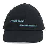 Front of a black baseball hat with Francis Bacon: Human Presence in bright blue. 