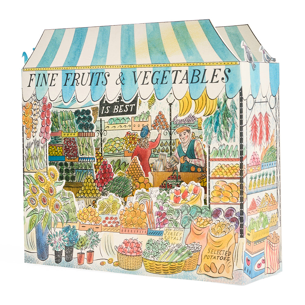 Side view of a 3d greetings card of an illustrated greengrocers stall with drawings of fruit, vegetables and the owner serving a customer inside.