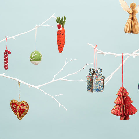 White tree branches holding colourful Christmas decorations. 