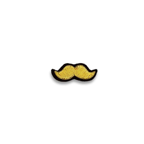 Gold colour moustache shaped embroidered brooch with black outline.