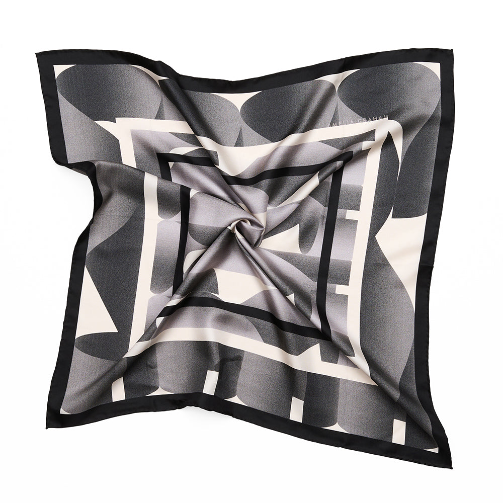 A styled square scarf with black and white squares surrounded by a grey swirled pattern.