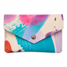 Colorful abstract-patterned wallet with a button closure on a white background