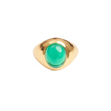 A chunky gold ring with a bright green stone in the centre. 