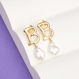 A pair of gold 'B' earrings with a single pearl drop from each.