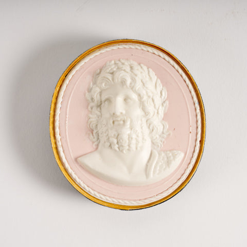 Oval paperweight in pink and white featuring a portrait of bearded man.. 
