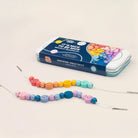 Beaded necklace kit with colourful beads and packaging on a light background