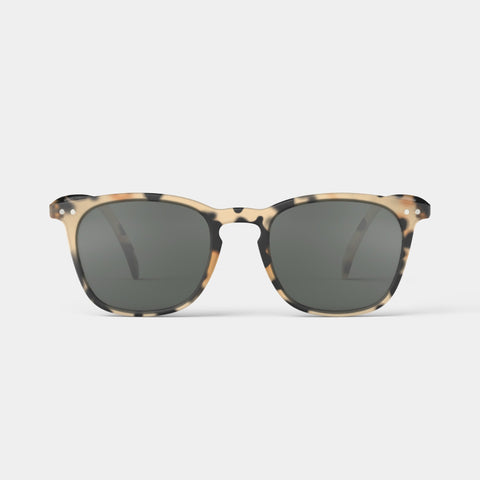 A pair of sunglasses in a light brown tortoiseshell frame.