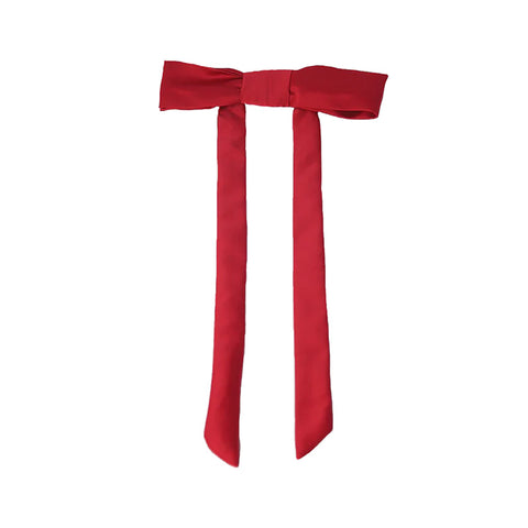 A hair clip featuring a long red fabric bow.