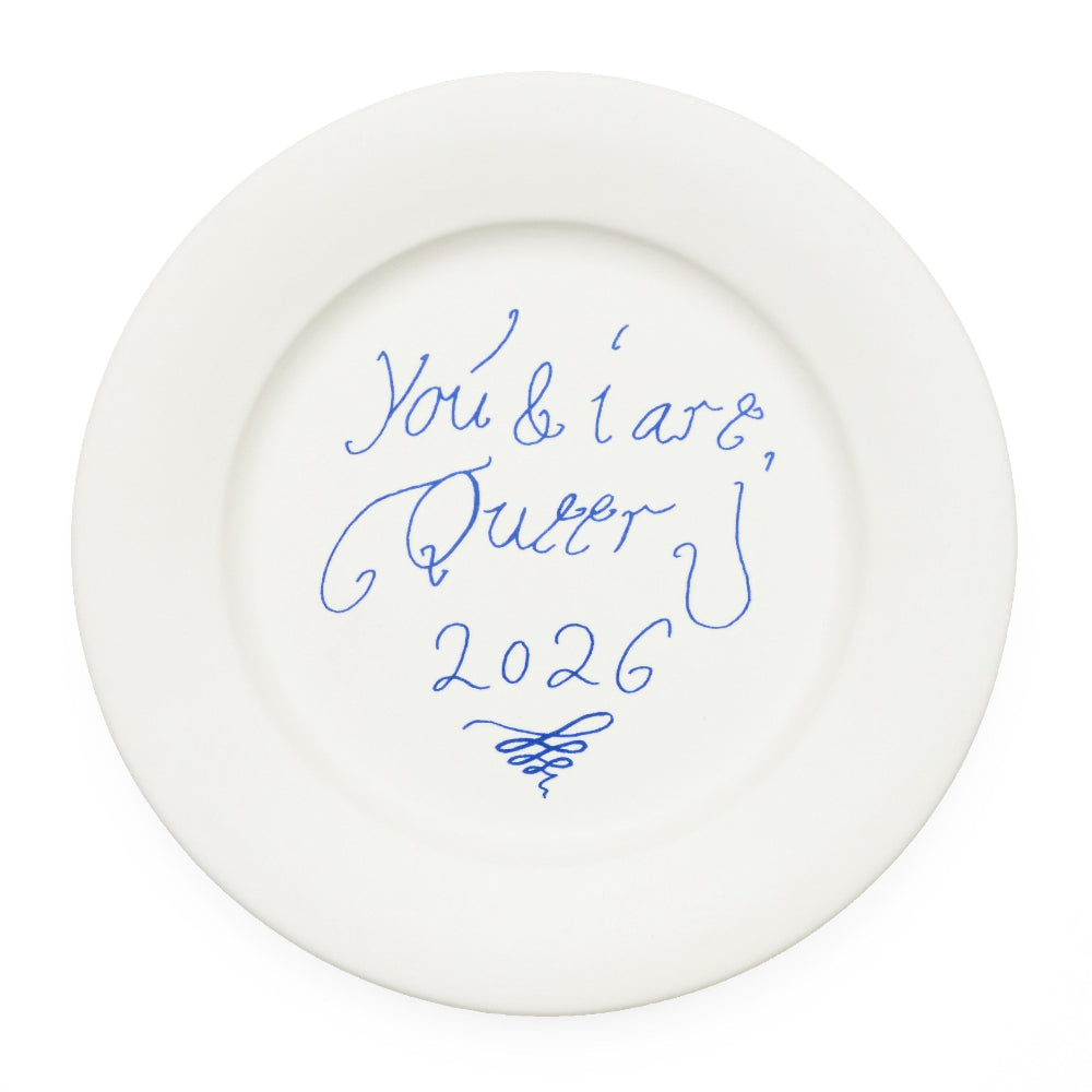 A white ceramic plate with blue cursive writing that reads 'you & i are queen 2026' shown on a plain white background.