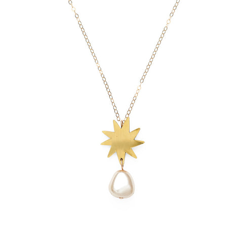 A gold brass star pendant with glass pearl below hang from a gold chain.