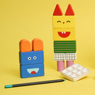 Colorful toy blocks assembled into a character on a yellow background