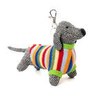 Stuffed dog toy with a colourful striped body and tweed herringbone fabric on a white background