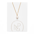 Large single pearl pendant handing from a gold chain necklace attached to NPG packaging.
