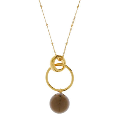 A gold chain necklace from which hangs 2 gold hoops with a small smoky grey glass ball hanging below.